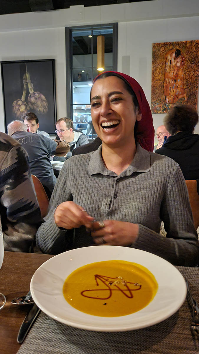 Abeera Kamran laughing at the drizzled glyph in her soup
