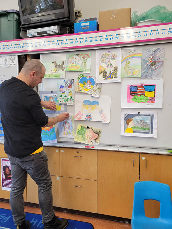 Andreas Segerberg at Malcolm X Elementary school displaying children's drawings from the Cherkasy Regional Library.